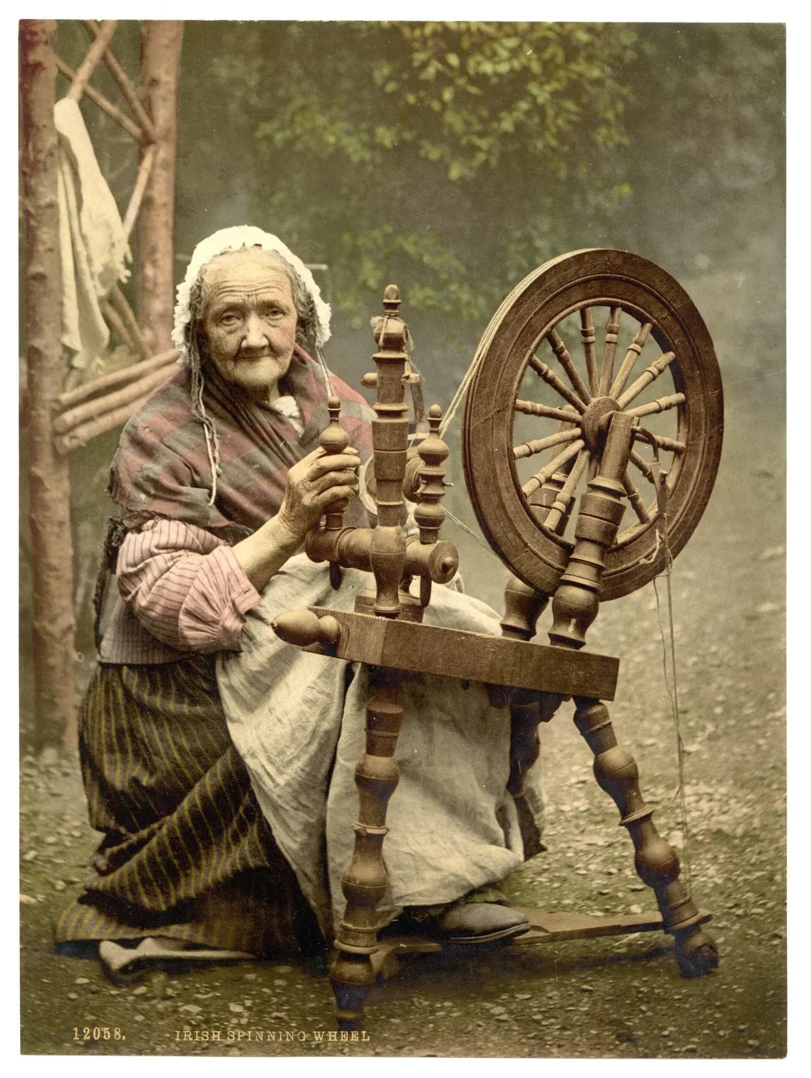 Photochrom print from about 1890 to 1900 of an elderly Irish woman seated at a spinning wheel